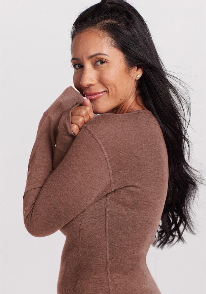 Woman with long dark hair in the Woolx Hannah Long Sleeve Top - Sable Heather, smiling and looking over her shoulder.