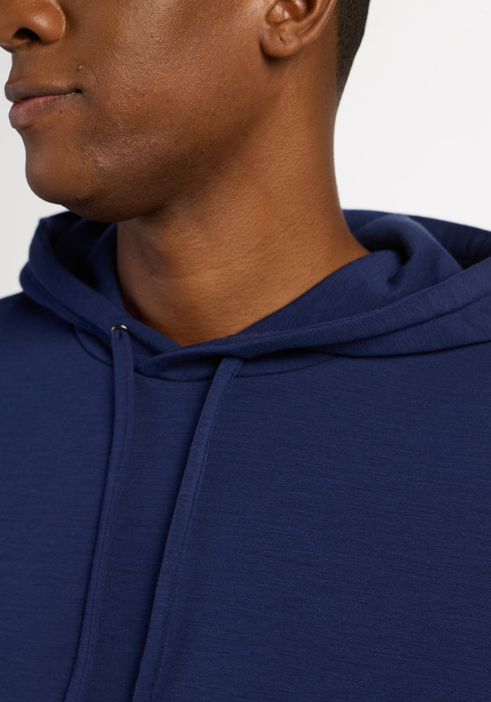 Close-up of a person in the Woolx Watson Pullover - Ocean Cavern, showing odor resistant hood, neckline, and face.