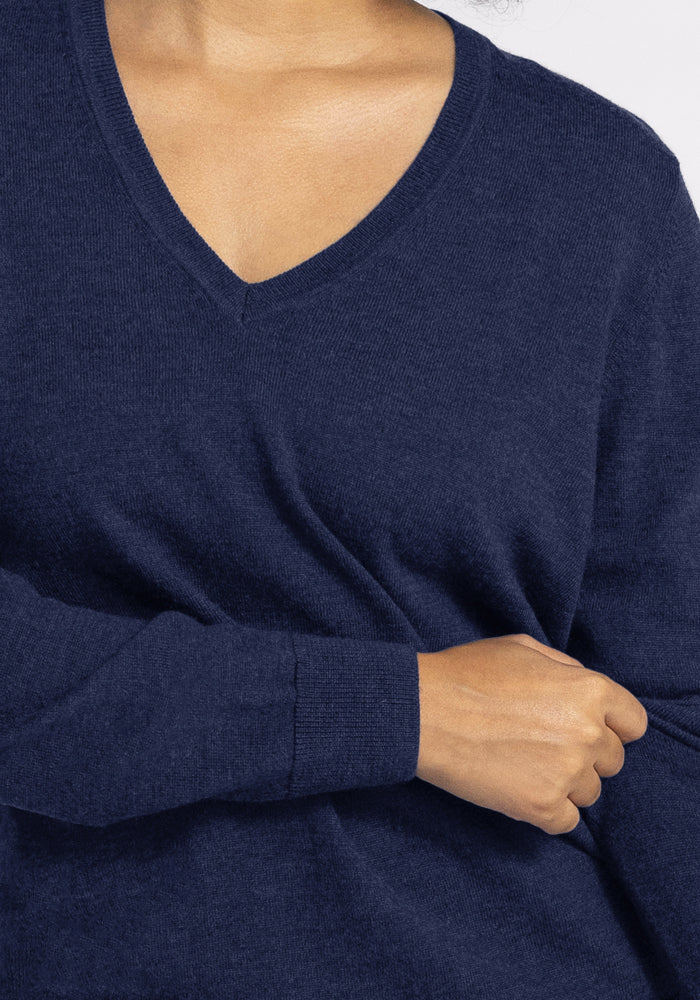 Model wears a Woolx Francesca Sweater in Ocean Cavern, one arm bent, hand resting at their side.