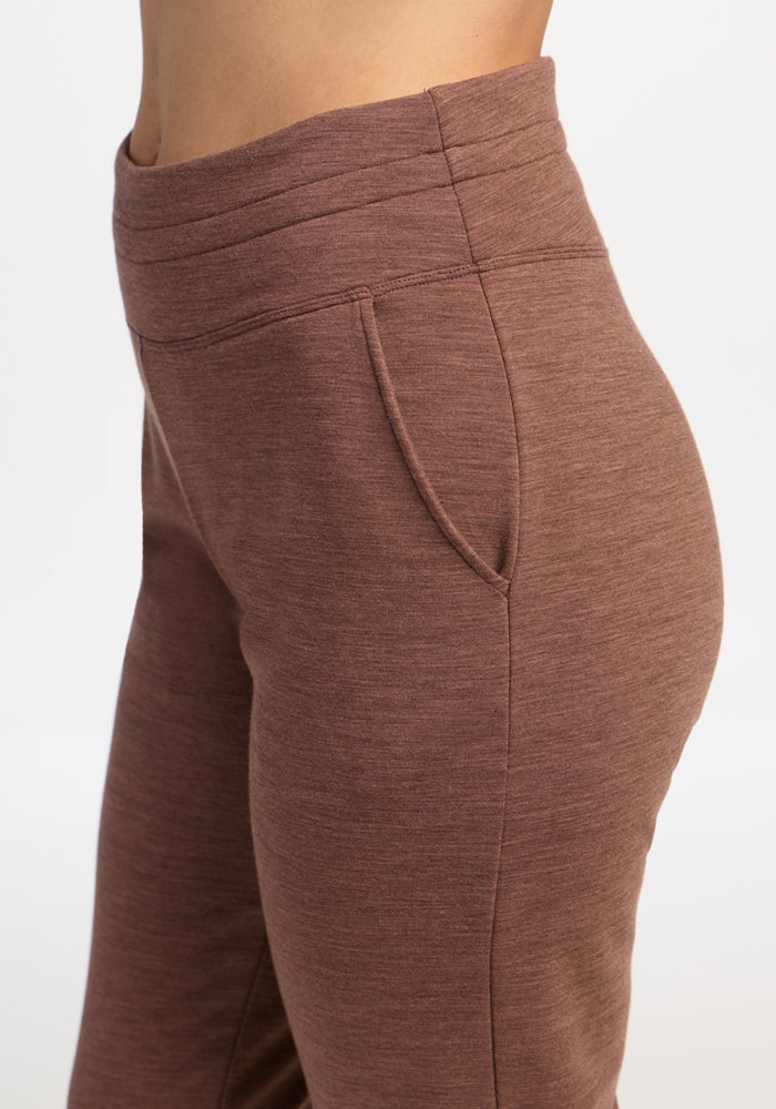 Side view of a person wearing Woolx Willa Joggers in Sable Heather, featuring front pockets.