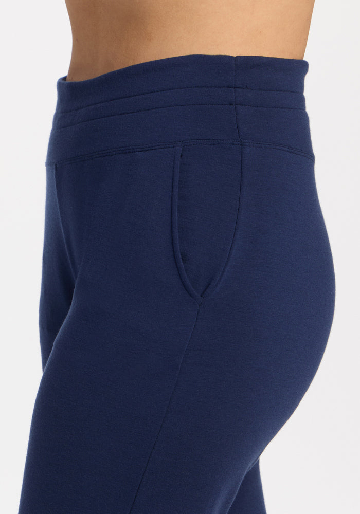 A side view close-up of a person wearing Woolx Willa Joggers - Ocean Cavern with a high waistband.