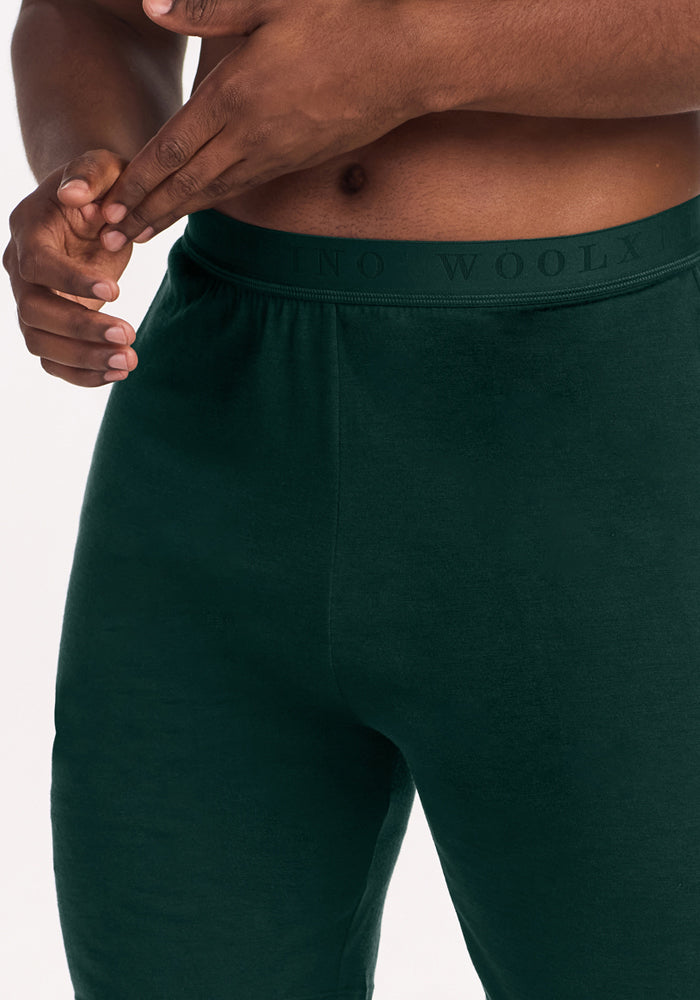 Deep Pine Archer Lounge Shorts in dark green merino wool with an elastic waistband featuring repeated text.