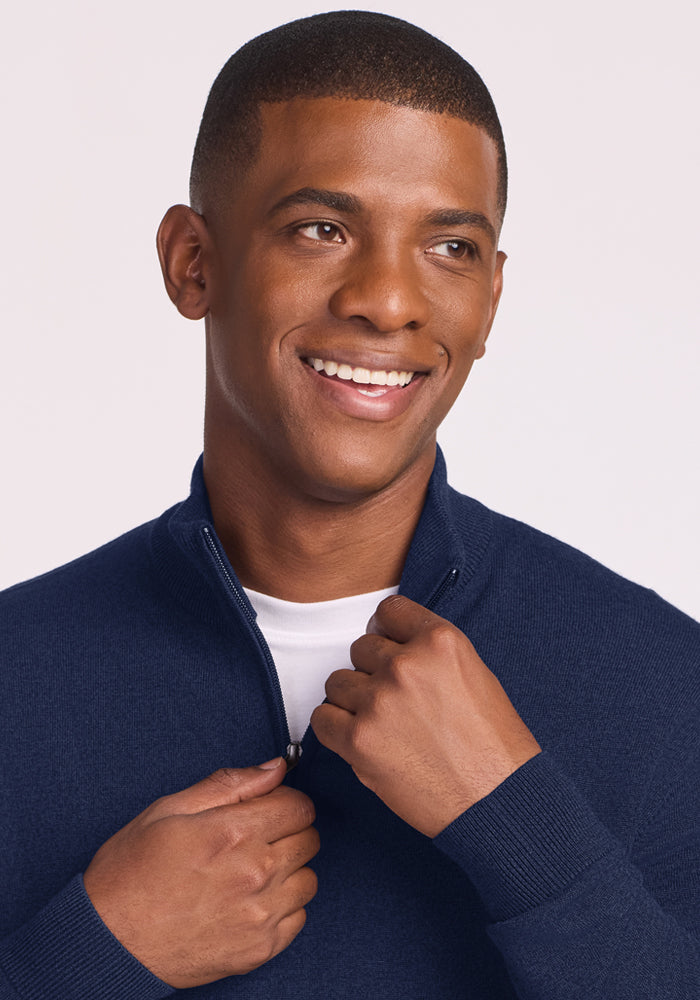 Man smiles in a Woolx Enzo Quarter Zip - Ocean Cavern, a midweight layer over a white shirt.