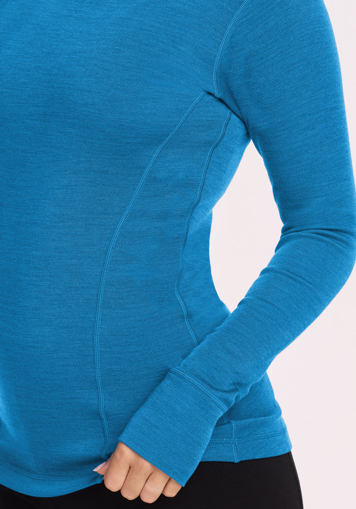 Person wearing a fitted Woolx Hannah Long Sleeve Top in Blue Razz with black pants, shown from shoulder to hip.
