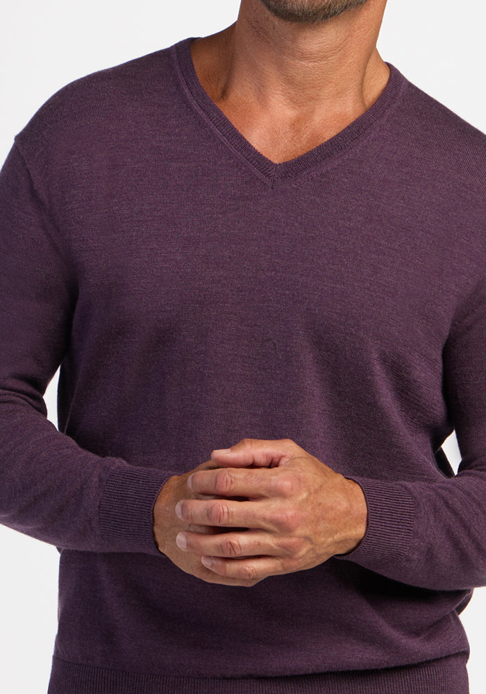 Man in Woolx Vincenzo Sweater - Purple Iris, V-neck, hands clasped, shown shoulders to waist.