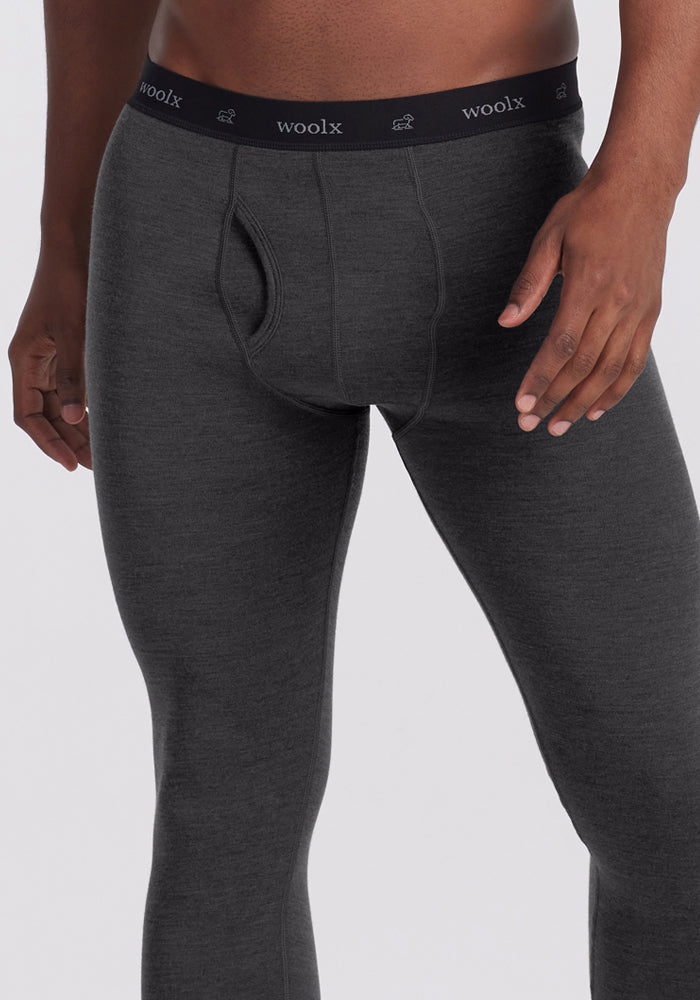 A man wears Woolx Backcountry Leggings in Cinder Melange, shown waist to mid-thigh against a plain backdrop.