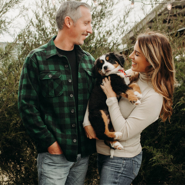 Man and woman wearing Woolx and holding puppy while standing outside