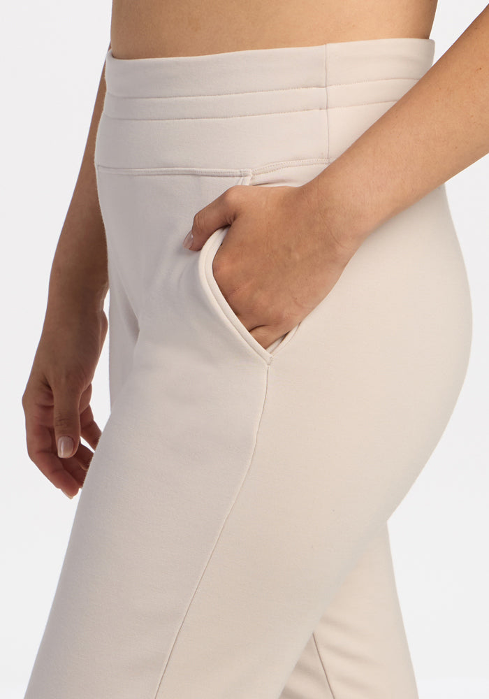 Model wearing Woolx Willa Joggers Petite in Ecru, side view from waist to mid-thigh, hand in pocket.
