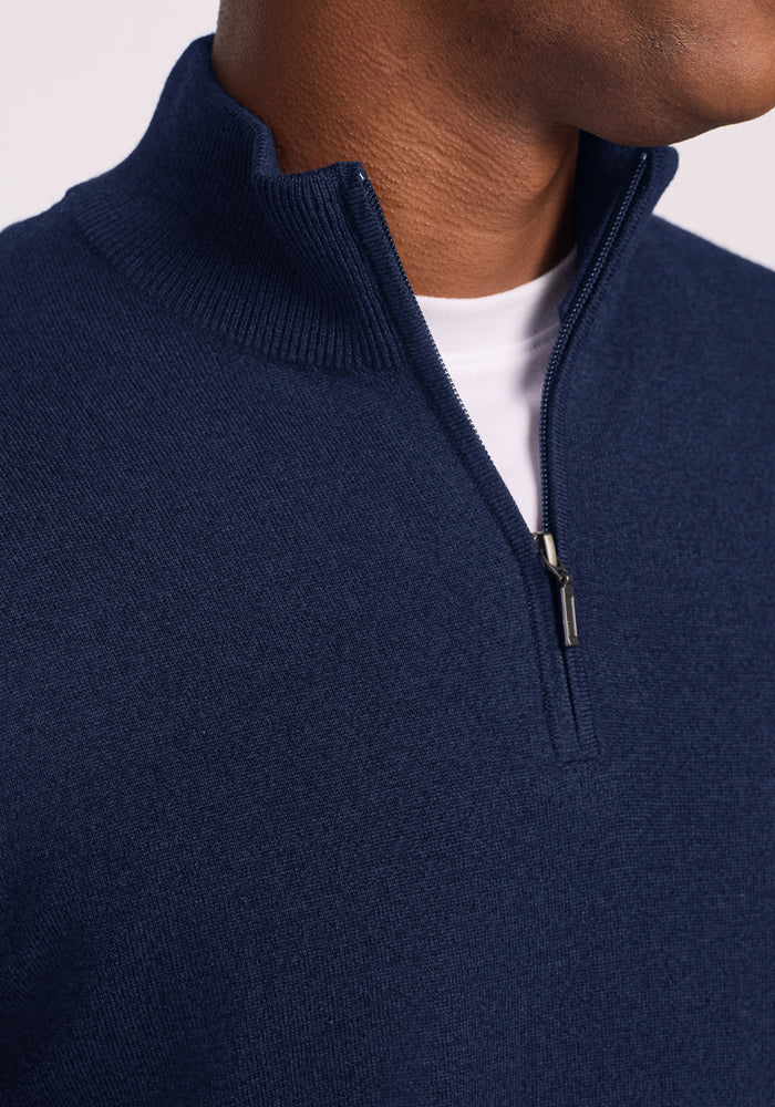 Close-up of a person in a Woolx Enzo Quarter Zip - Ocean Cavern, midweight layer, partially unzipped over white shirt.