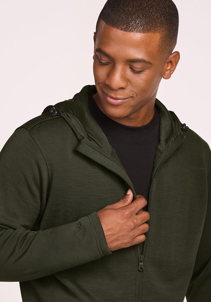 A man wearing a dark green Woolx Grizzly Sweatshirt - Duffel Bag over a black shirt.
