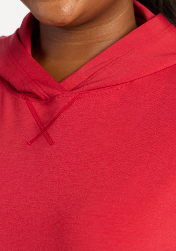 Close-up of a person smiling in the Woolx Lizzy Hoodie - Maraschino Cherry, made from buttery soft Meriluxe fabric.