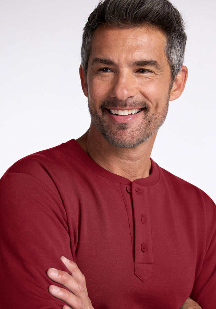 Smiling man in Woolx Jackson Henley - Pinot Noir, short gray hair, against a light, minimalistic background.
