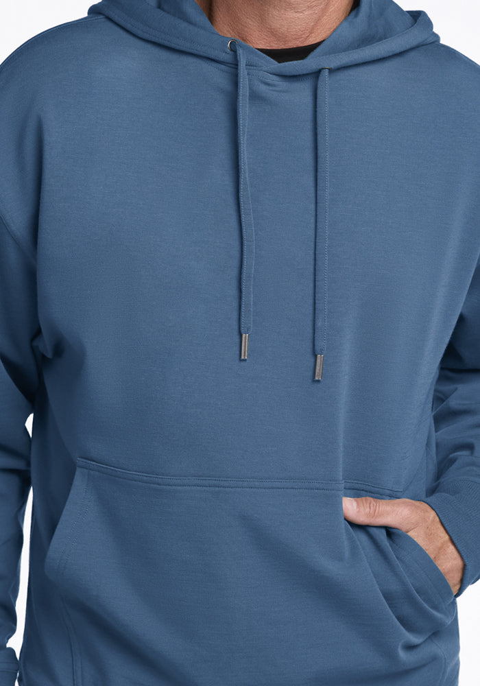 Model in Woolx Chase Hoodie - Blue Ashes, hand in pocket, shown shoulder to waist.