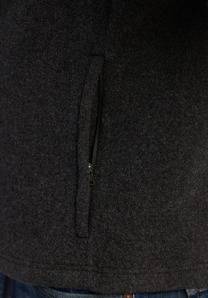 Close-up of a charcoal gray Everest Vest - Carbon Black with a vertical zippered pocket.