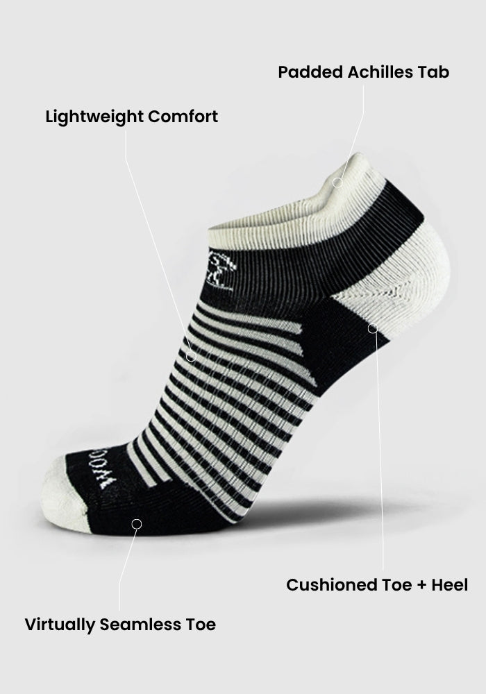 The Woolx Womens Amelia No Show Tab Lightweight Socks in Tuxedo Stripe feature a padded Achilles tab, cushioned toe and heel, reinforced heel and toe, striped black and white design, moisture-wicking fabric, and a virtually seamless toe.