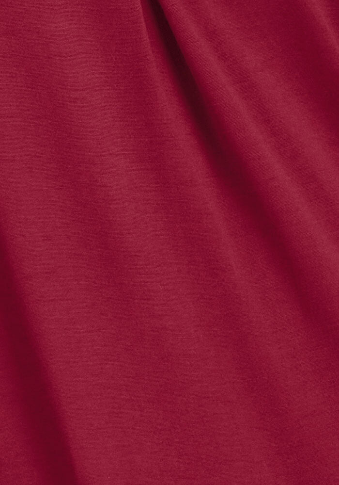 Close-up of beet red Woolx Lucille Long Sleeve Nightgown fabric with soft, diagonal folds.