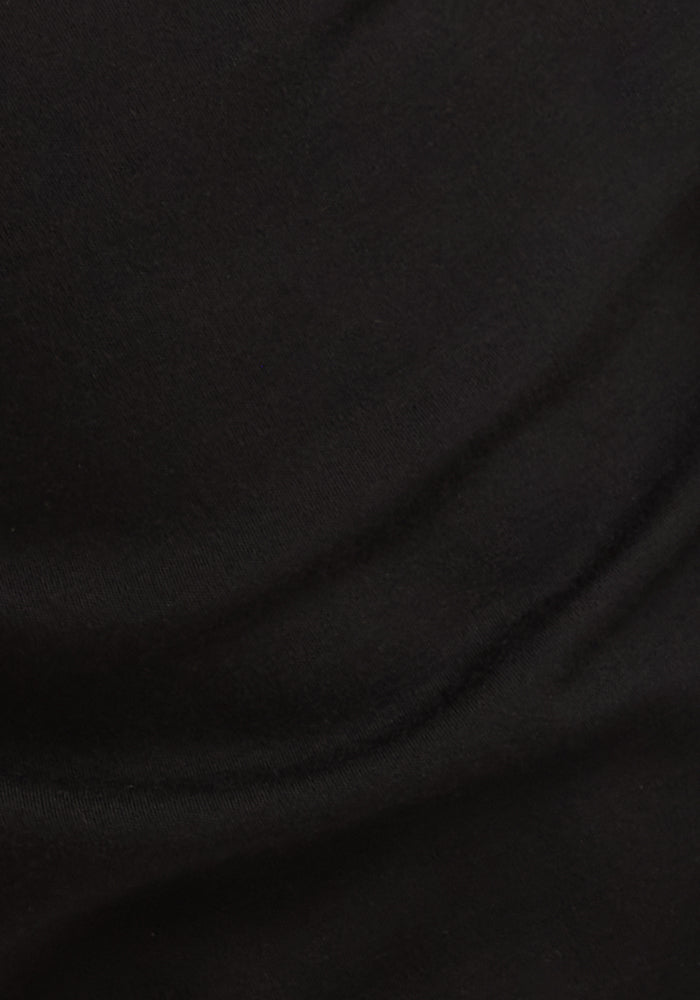 A close-up of smooth, black Australian Merino wool from the Woolx Kids Explorer Base Layer Top, showing subtle folds and texture—ideal for a moisture-wicking kids top.