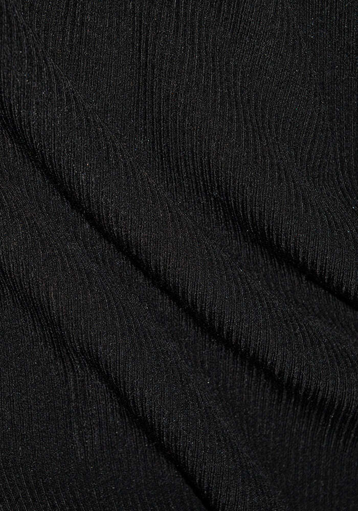 Close-up of Woolx Ainsley Petite Sweater in black, showing ribbed Merino wool with diagonal folds and texture.