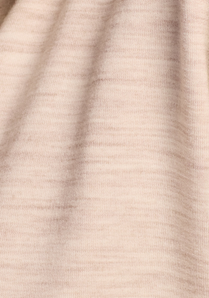 Close-up of the Edna Hooded Cardigan by Woolx in Cream Heather, featuring fine horizontal lines and soft folds in light beige merino wool for a smooth yet subtly textured look.