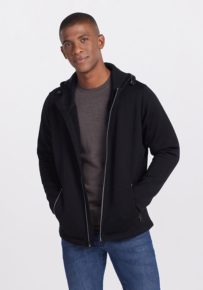 A man wearing a black Grizzly Sweatshirt over a dark grey t-shirt and blue jeans. | Trell is 6’2”, wearing a size M