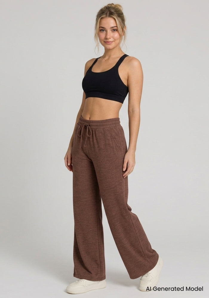 Woman in Woolx Eloise Petite Pants - Sable Heather smiles, showing the adjustable drawstring waistband.