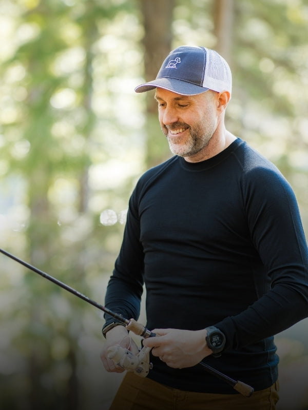 Man holding a fishing rod in a forest setting