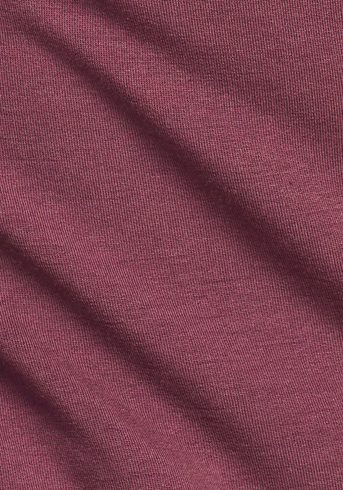 Close-up of the Woolx Easton Crew Neck Shirt in Grape Harvest, showing its maroon merino wool knit fabric with fine texture, diagonal folds, and gentle shadows.