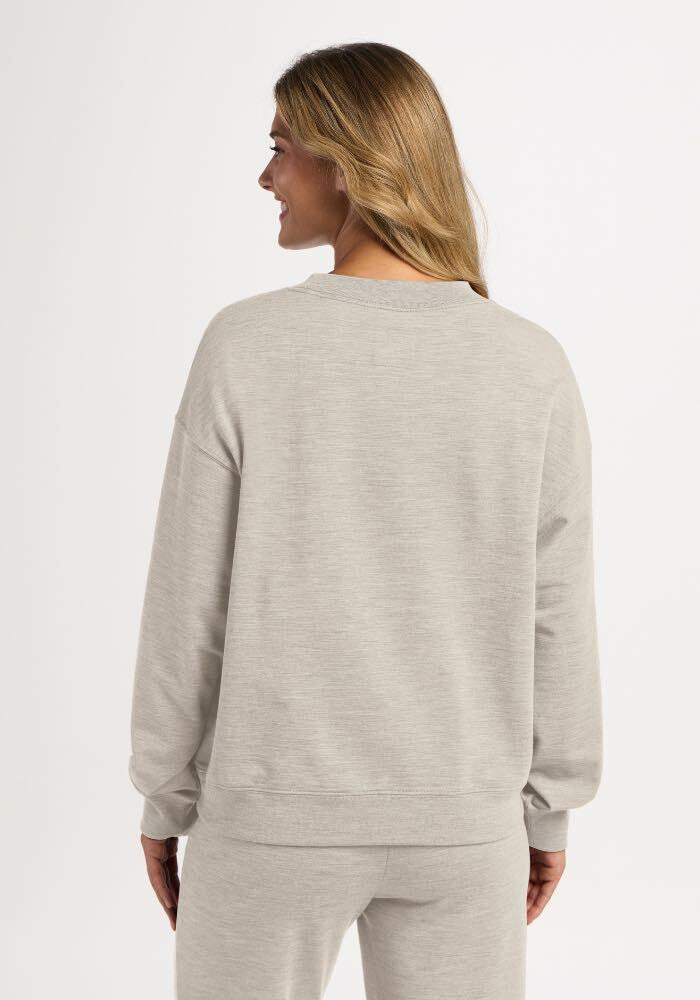 Woman seen from behind wearing a light ash Woolx Molly Crewneck and matching sweatpants.