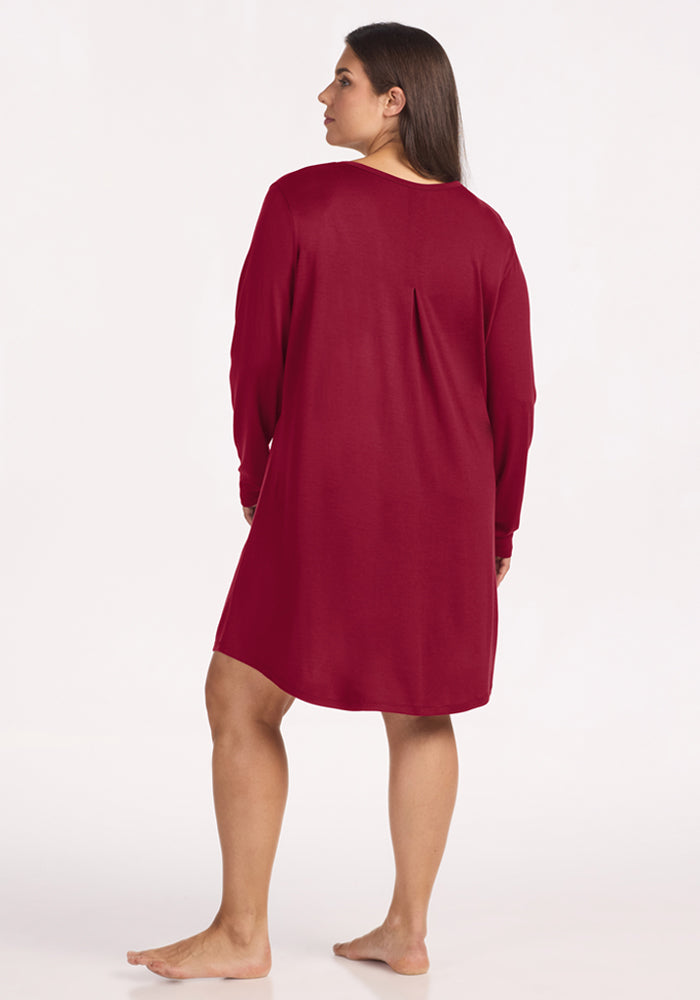 A person seen from behind, wearing a beet red, temperature regulating Lucille Long Sleeve Nightgown.