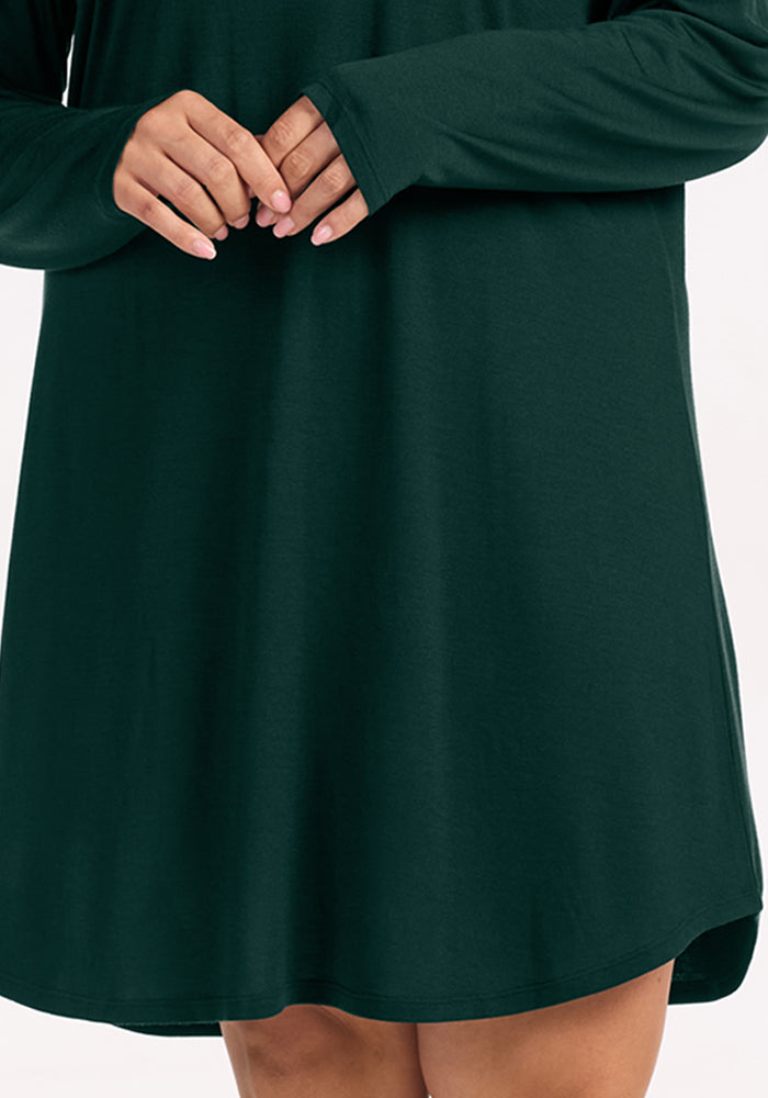A person wearing a dark green, long-sleeved Woolx Lucille Long Sleeve Nightgown - Deep Pine.
