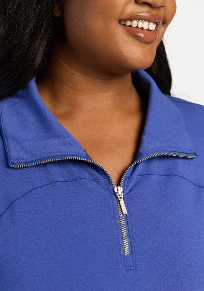 Close-up of a royal blue Woolx Tori 1/4 Zip merino pullover with a silver zipper.