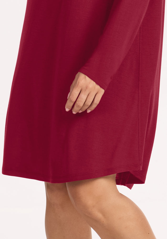 A person wearing a beet-red Woolx Lucille Long Sleeve Nightgown that falls above the knee.