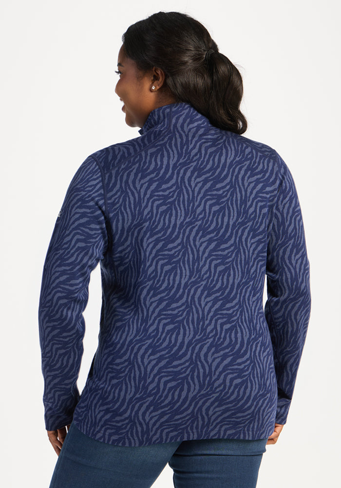 Woman in ponytail wears Woolx Emi 1/4 Zip - Midnight Safari jacket over jeans, facing away.