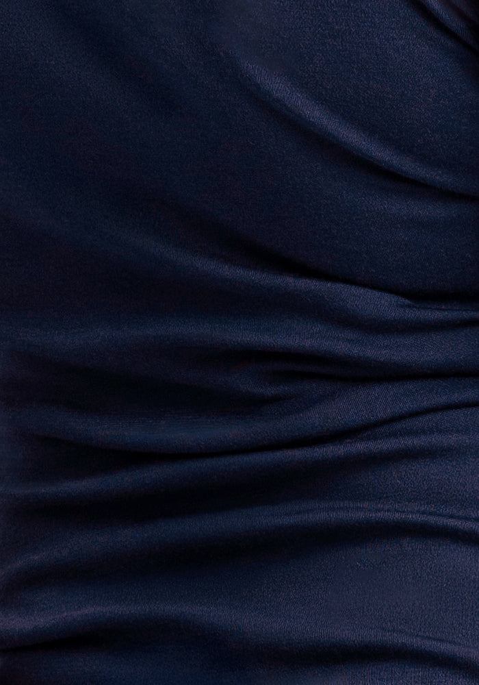 Close-up of dark blue, slightly shiny fabric from the Woolx Peyton Turtleneck in Midnight Sapphire, with soft folds and textured surface—ideal for a lightweight, warm sweater.