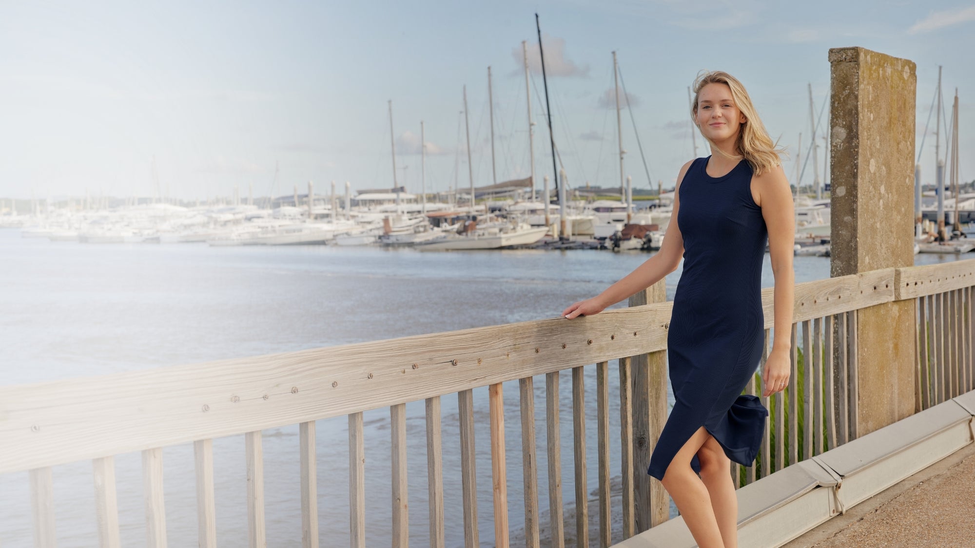 Woman wearing a blue dress on a pier. 