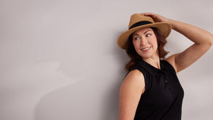 Model wearing new black Rosie polo and hat