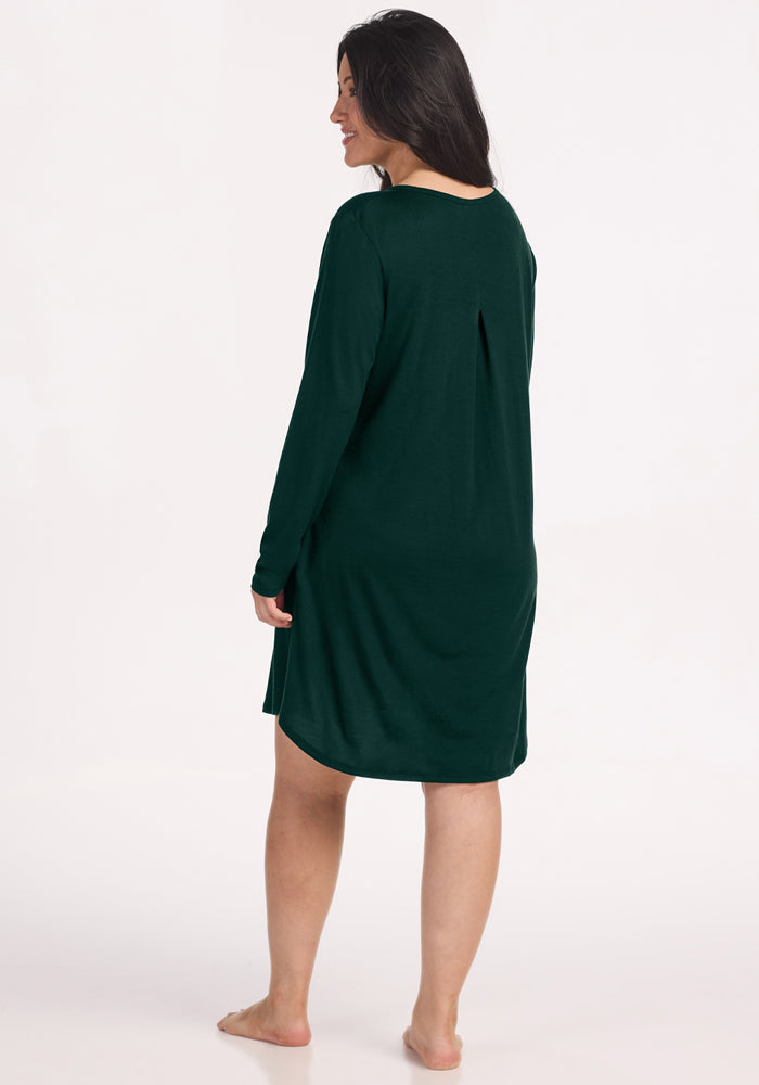 Woman wearing a Woolx Lucille Long Sleeve Nightgown - Deep Pine, a dark green, temperature-regulating, pleated-back gown.