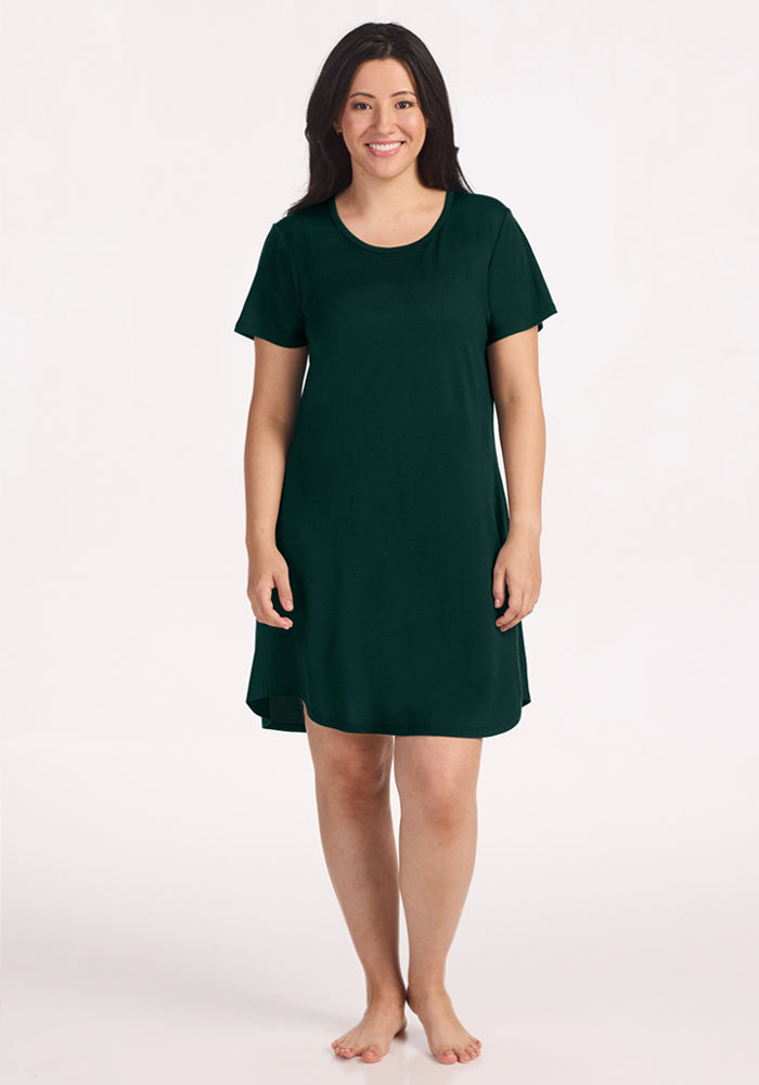 A woman in a Deep Pine Woolx Desi Nightgown, a dark green, moisture-wicking, short-sleeved, scoop-neck wool piece.