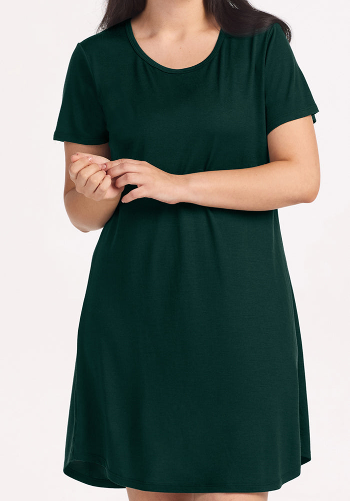 Person wearing a short-sleeved dark green Woolx Desi Nightgown - Deep Pine with a scoop neckline.
