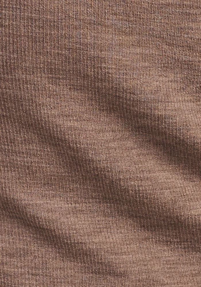Close-up of Woolx's Sage Ribbed Turtleneck in Simply Taupe, highlighting its soft Merino wool fabric with fine vertical lines and gentle folds that showcase the flexible, textured women’s winter sweater material.