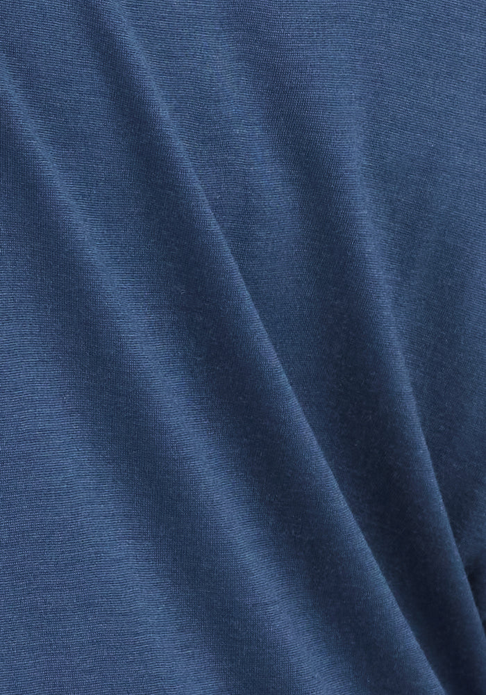 A close-up of the Woolx Layla V Neck Top in Starry Night shows soft, smooth Merino wool fabric with gentle folds, highlighting its odor-resistant properties.