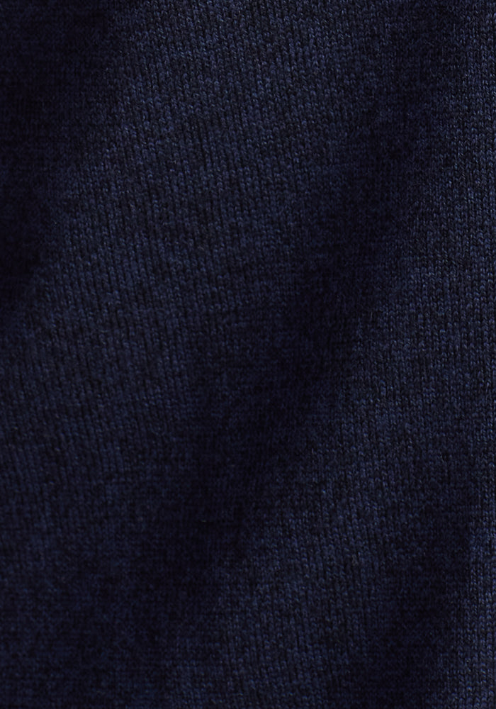 Close-up of the Woolx Collins Half Zip Sweater in Storm Cloud, highlighting its dark blue textured Merino wool with visible knit patterns and gentle shadows accentuating soft folds.