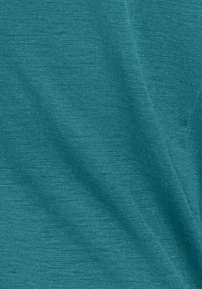 Close-up of the Ryann Hoodie - Tidepool by Woolx, featuring teal merino wool fabric with a soft, slightly textured surface and gentle folds.