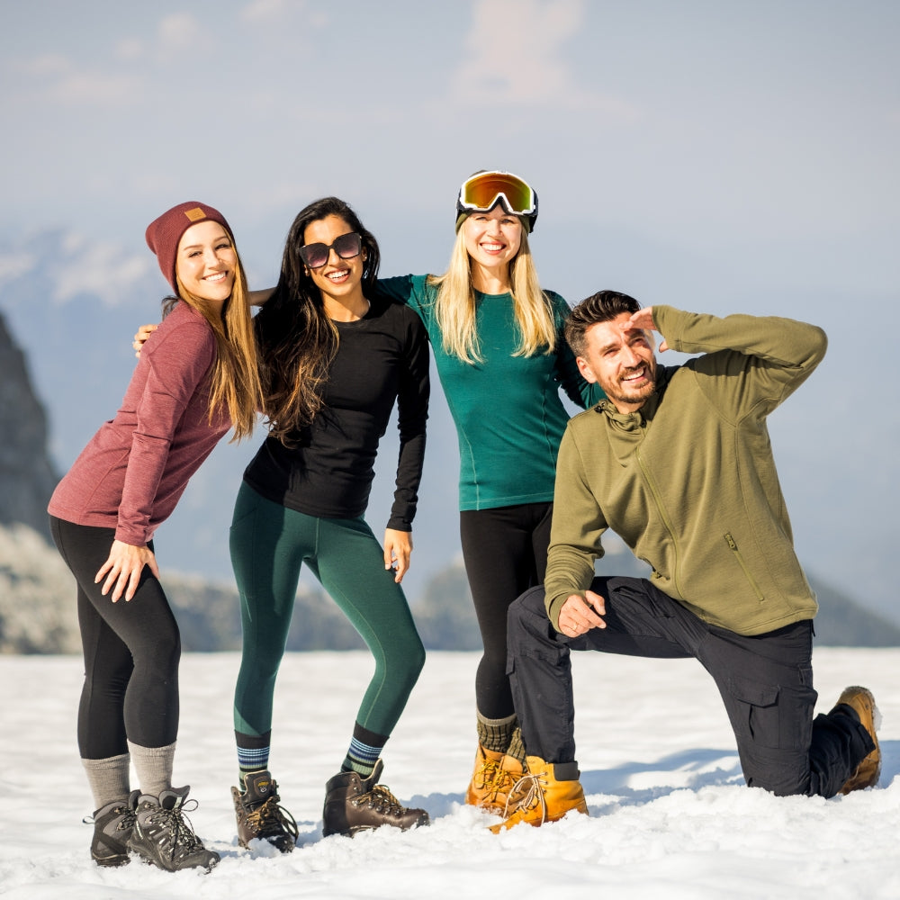 Group of people standing on mountain in base layers and accessories