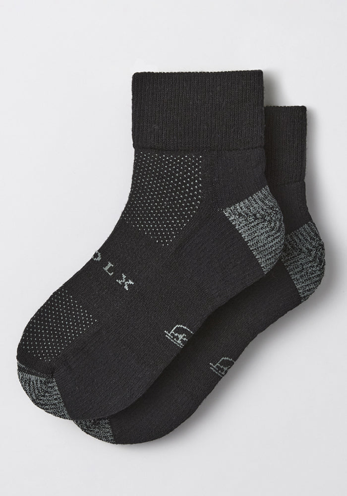 The Woolx Mens Rambler Ankle Sock in Black Pepper features gray toe and heel accents, white dotted patterns, and subtle side text, designed for superior moisture management and all-day comfort.