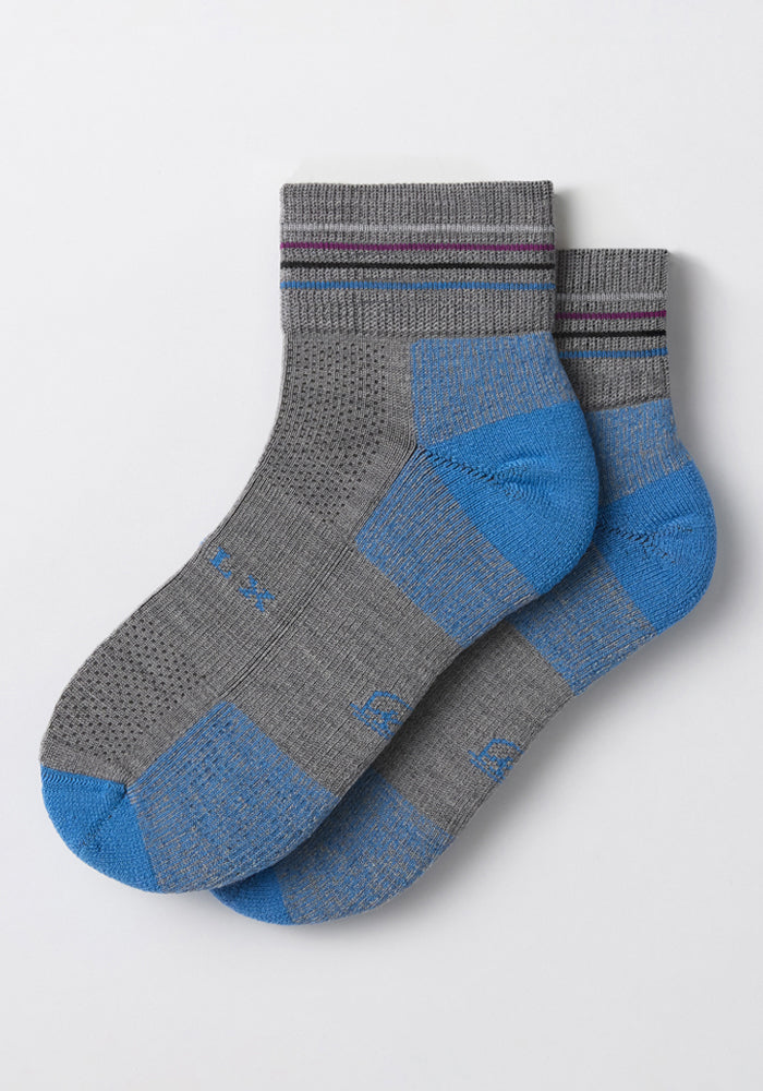 The Woolx Womens Rambler Ankle Sock - Dolphin features gray Merino wool with blue heels and toes, thin dark purple stripes near the top, and is laid flat on a light background for comfort and moisture control.