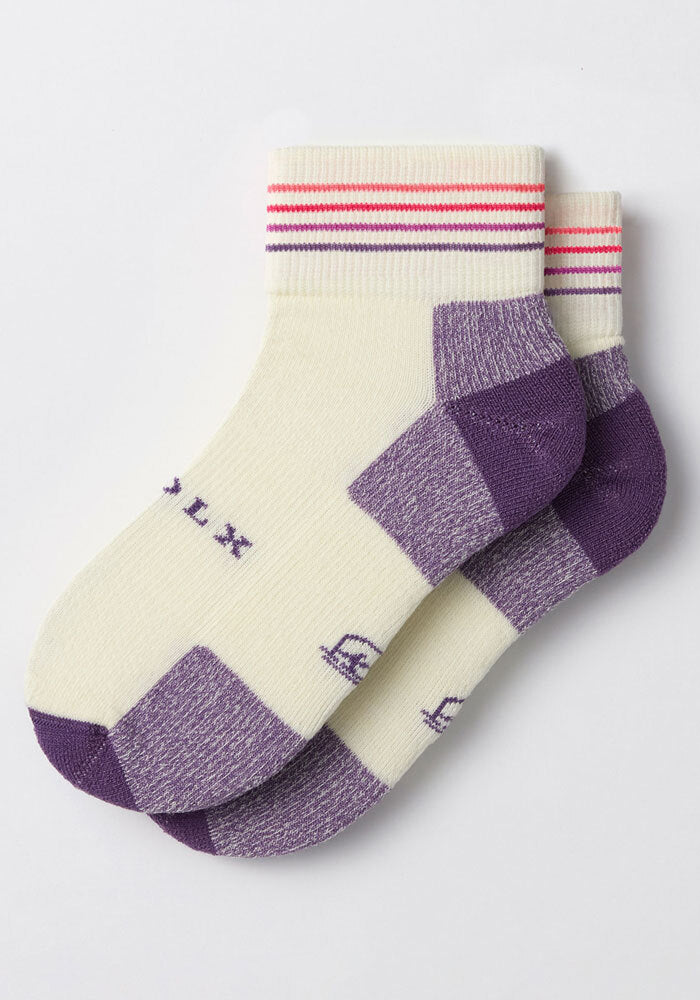 The Woolx Womens Rambler Ankle Sock - Sand Dollar features cream uppers with purple heels, toes, and soles plus red and pink stripes. Laid flat and slightly overlapping on a white background, these Merino wool socks provide excellent moisture management.