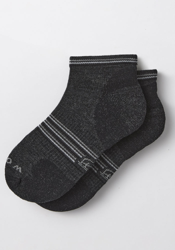 The Woolx Womens Amelia No Show Socks in Dark Grey Charcoal feature light gray stripes near the toes and cuff, are made from moisture-wicking Merino wool, and are displayed on a white background.
