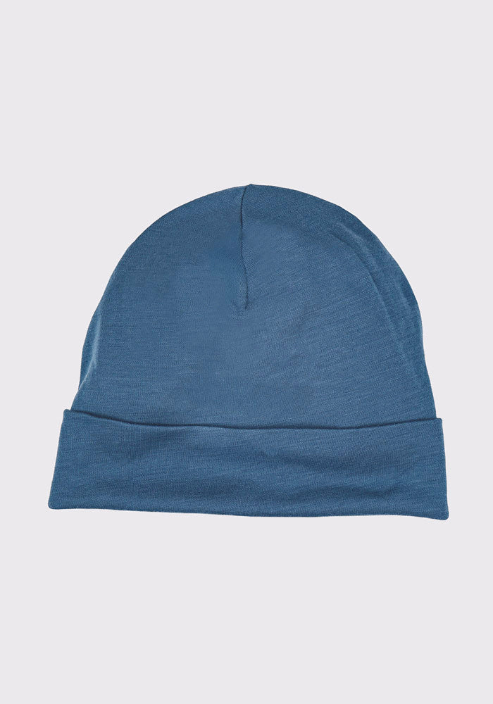 The Woolx Journey Hat in Steel Blue is a plain knit Merino wool beanie with a folded brim, shown against a light gray background.