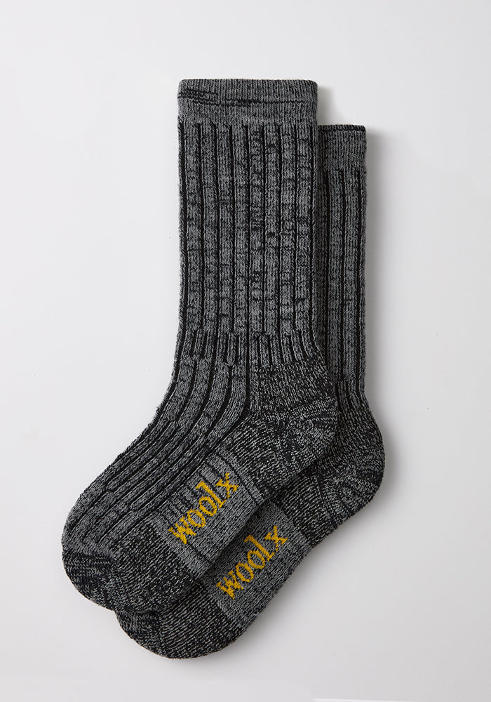 Two dark navy marled men’s Joey mid-calf Woolx socks, “Woolx” in yellow on soles, laid flat on a white background.